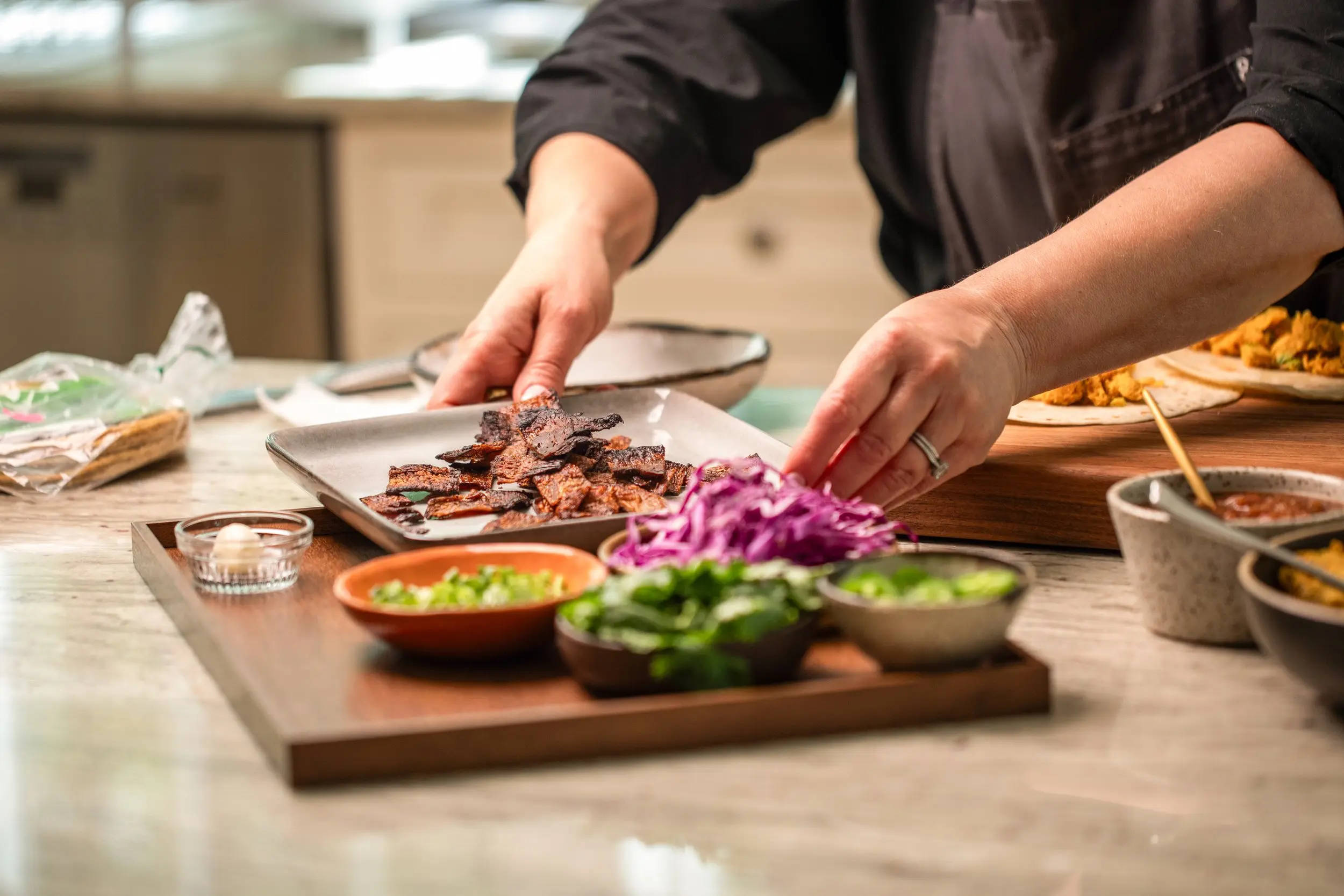 Photo of chef placing cooked plate of MyBacon on tray of ingredients