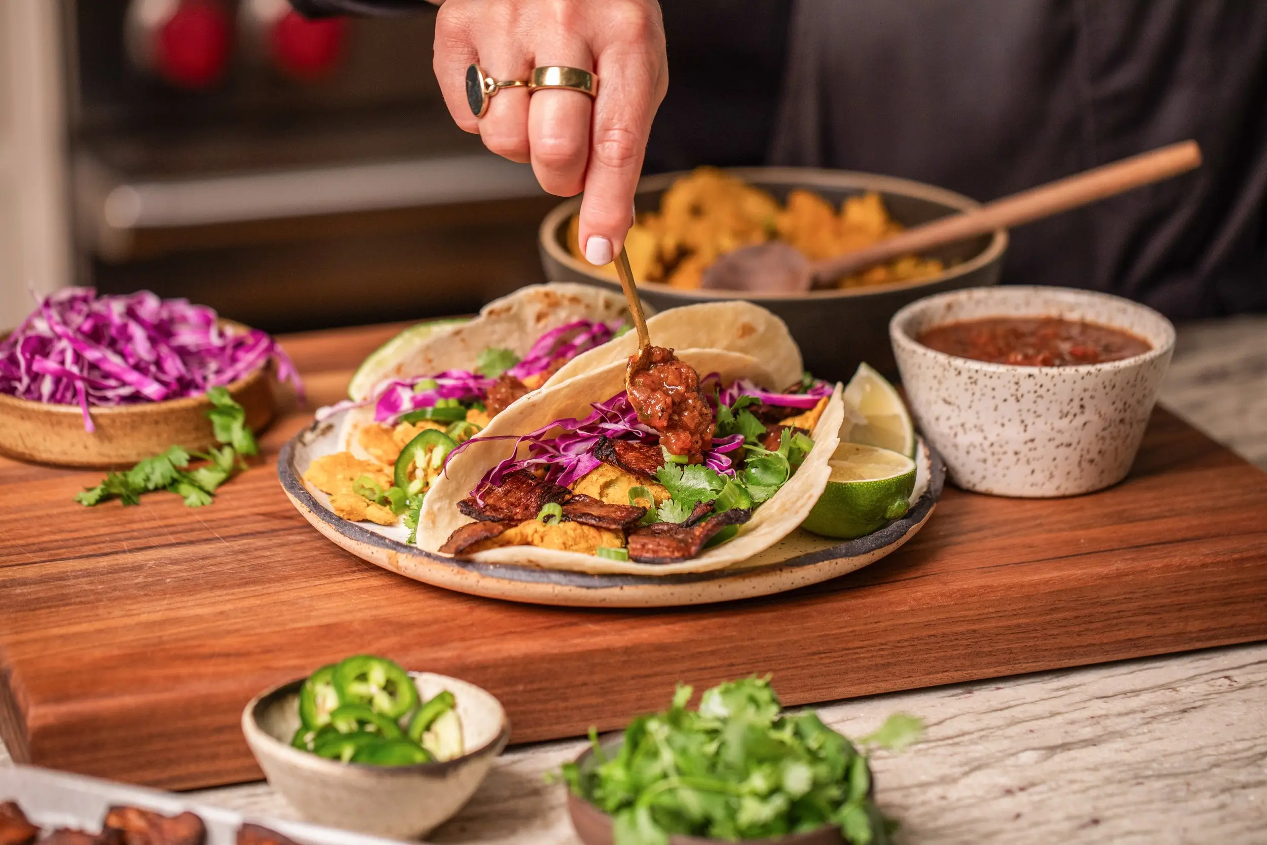 Photo of chef spreading salsa on MyBacon Breakast Chickpea Tacos