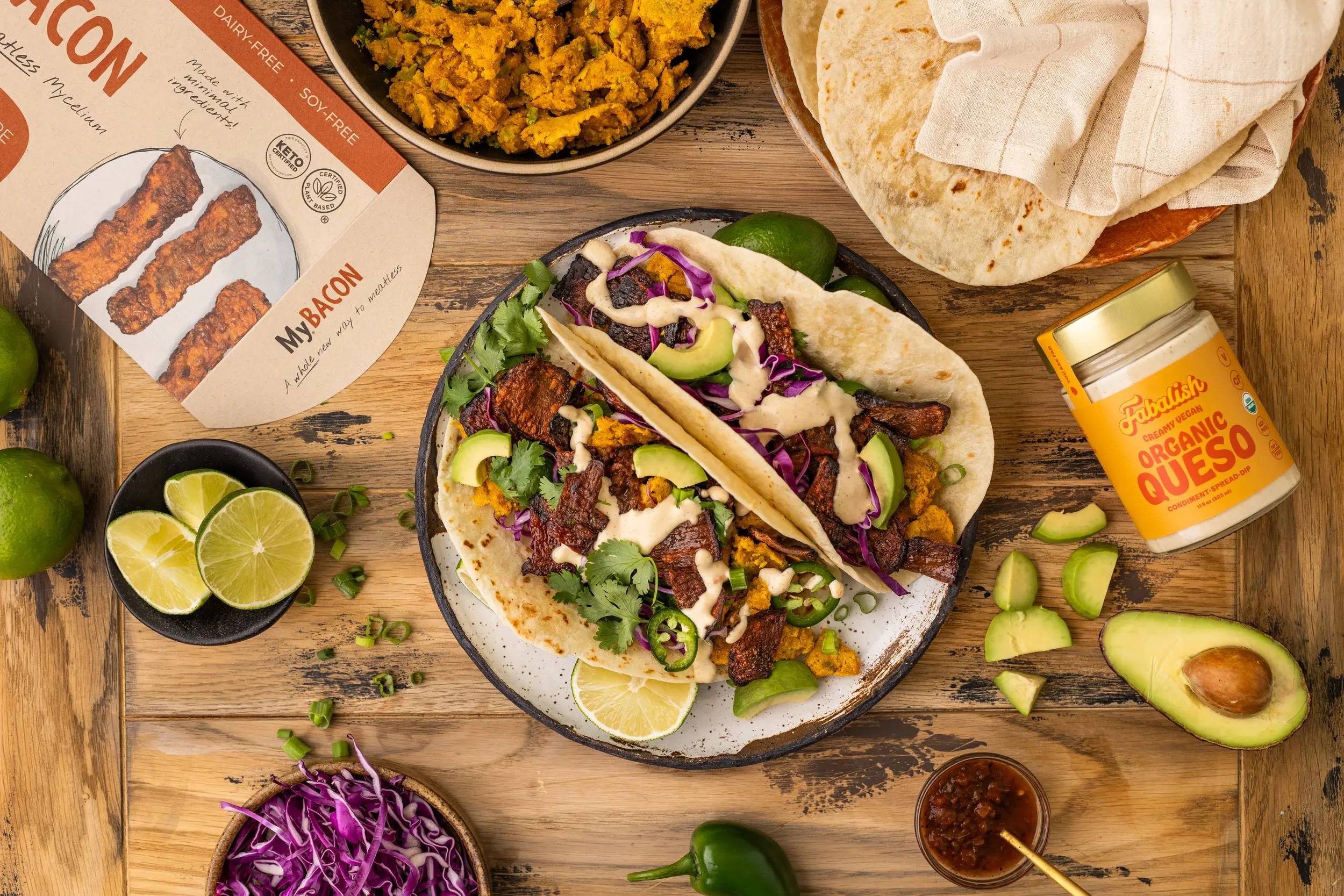 Top-down image of MyBacon Breakfast Chickpea Tacos with Fabalish Queso displayed with MyBacon and Fabalish packaging