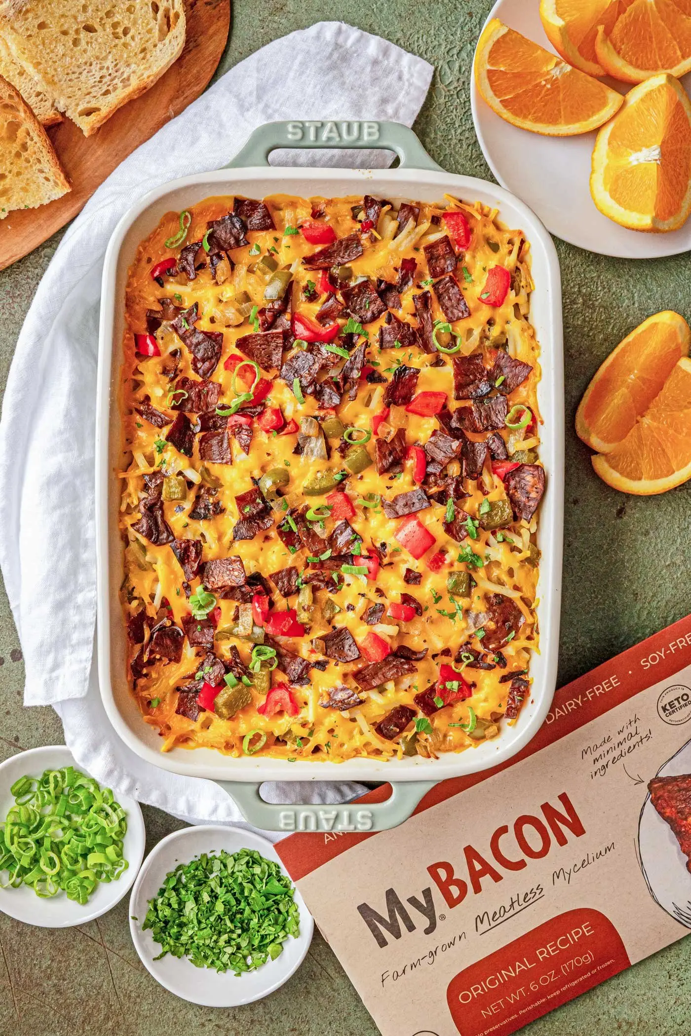 Top-down fully cooked pan of MyBacon Breakfast bake sitting on counter ontop of a white towel.