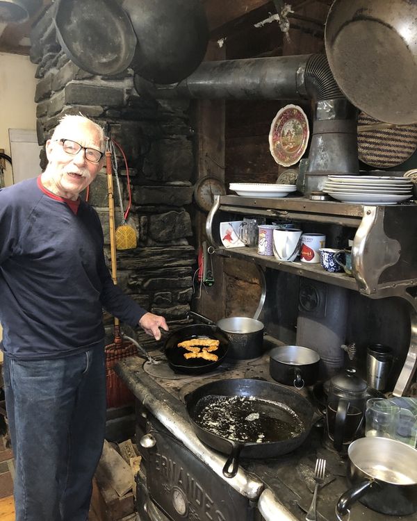Eben Bayer's father cooking MyBacon in a skillet on the family farm's wood stove