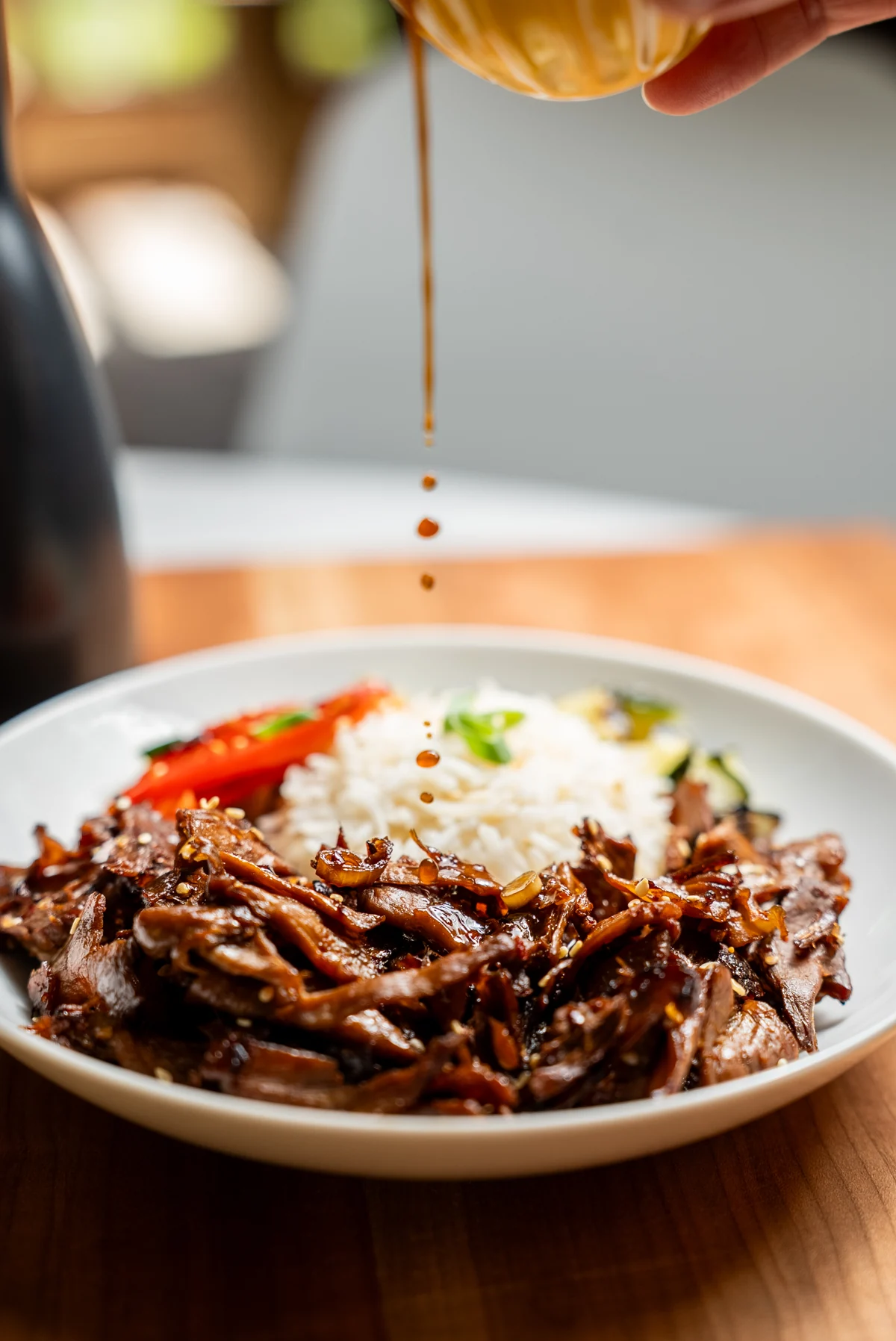 Sauce poured over seared MySteak in a rice bowl with vegetables