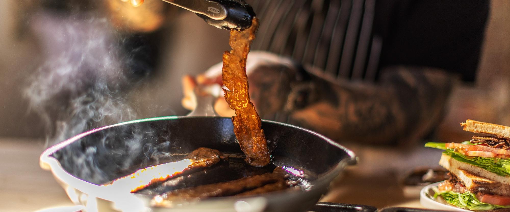 MyBacon crisping in a cast-iron skillet